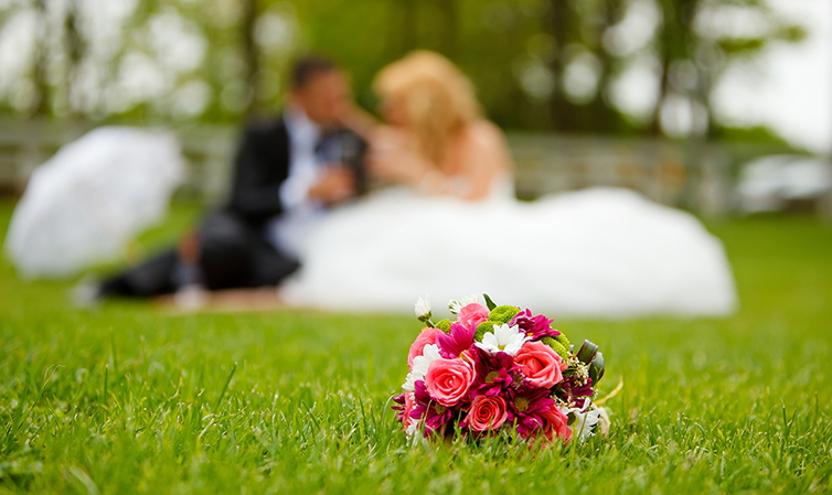 Bride and groom sat on the grass